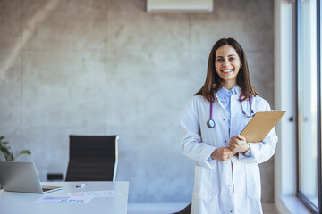 Smiling Female Doctor Holding a Clipboard in a Modern Office Setting