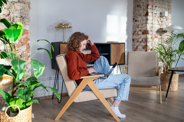 Focused woman freelancer working remotely planning online project in home office enjoying...