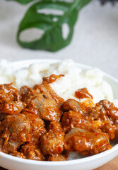 A bowl of South African street food, spicy chicken livers with traditional pap