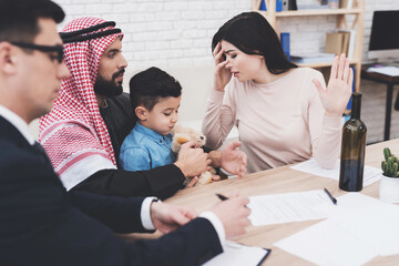 Lawyer in office with arab husband and wife. Man and woman are signing divorce papers.