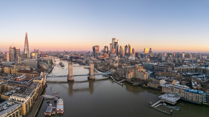 Tower bridge, London Tower, with surrounding skyscrapers of the downtown, at dawn, wide aerial view