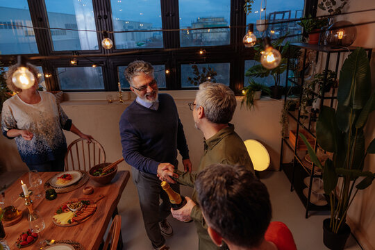 Friends celebrating retirement with festive dinner and champagne toast