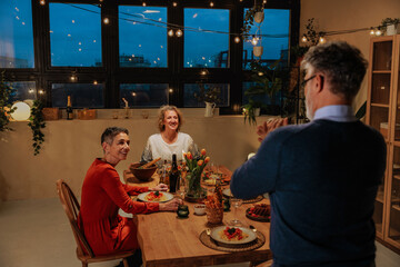 Senior friends celebrating pension with a cozy dinner party