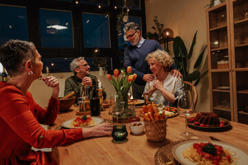 Group of Senior Friends Celebrating with a Festive Dinner at Home