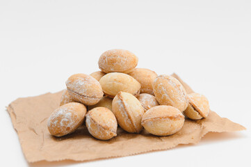 Delicious nut shaped cookies with boiled condensed milk on white background