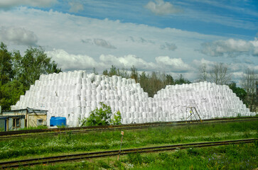 Fototapeta premium Stacks of White Bags Against a Blue Sky in a Rural Scene