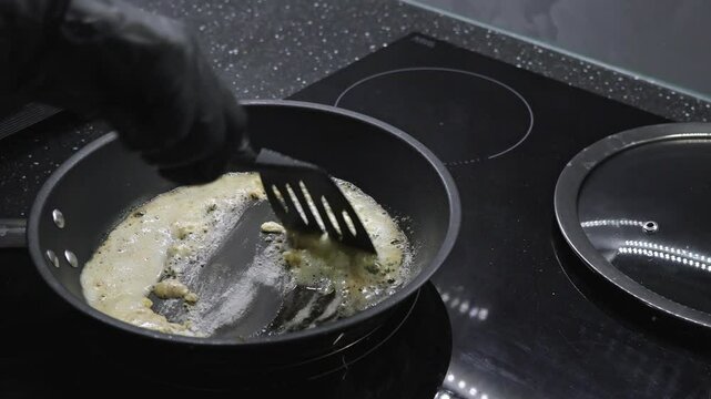 frying flour in butter on a pan while stirring to create a smooth roux base for thickening sauces, soups, and gravies