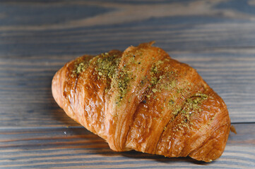 fresh baked croissant isolated on a wooden background