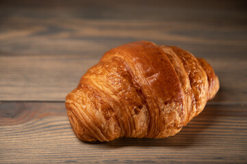 fresh baked croissant isolated on a wooden background