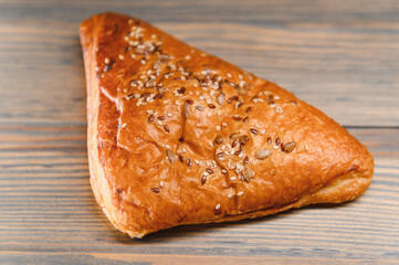 Puff pastry triangle filled with with jam on a wooden background