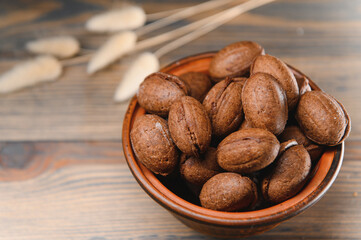 Delicious nut shaped cookies with boiled condensed milk on a wooden background