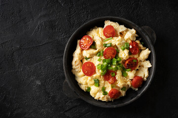 Scrambled eggs with onion and tomatoes on plate