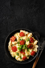 Scrambled eggs with onion and tomatoes on plate