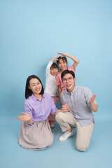 Cheerful family portrait with two children in playful poses against a light blue background, showcasing a moment of joy and togetherness