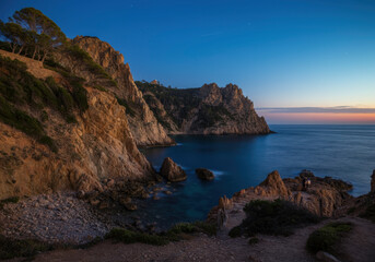 Fototapeta premium Stunning coastal cliffs under a twilight sky, where rocky formations meet the deep blue sea. A tranquil seascape capturing the raw beauty of nature.