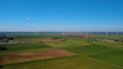 Wind Turbine in a Green Field on a Sunny Day – 4K Aerial Drone Footage - Powered by Adobe