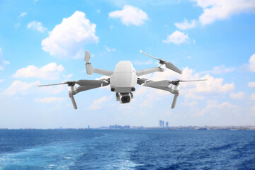 Naklejka premium Drone with camera flying over sea. Unmanned aerial vehicle for surveillance