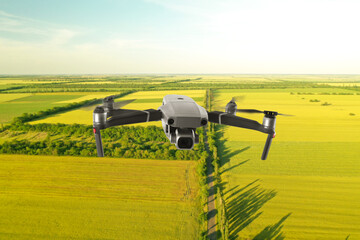 Drone with camera flying over fields. Unmanned aerial vehicle for surveillance