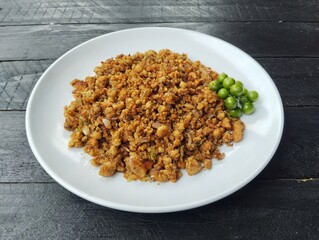 Oseng-oseng oncom or Indonesian food culinary, on plate on black wooden table background