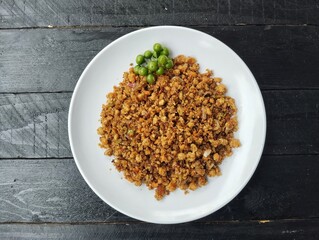 Oseng-oseng oncom or Indonesian food culinary, on plate on black wooden table background