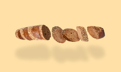 Freshly baked baguette. Pieces of bread in air on beige background