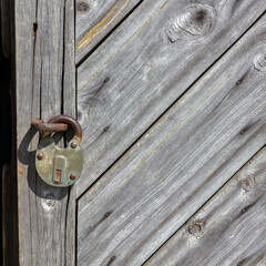 Fragment of Aged Boarded Wooden Door with Iron Padlock.
