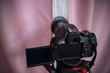 Digital video camera hidden behind pink curtains, spying neighbors Peeping. Spying. Surveillance.  ...