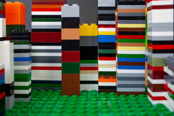 Tall building blocks towers background on green desk , abstract textured backdrop