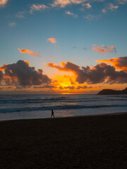 Silhouette of one person walking at the beach at sunrise time.