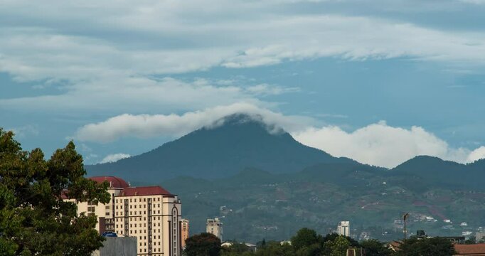 Timelapse of clouds rolling over the mountain top in the afternoon in Bandung, Indonesia