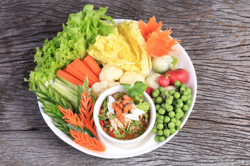 Spicy Crab Roe Relish Paste serve with Mixed fresh vegetables on vintage wood background