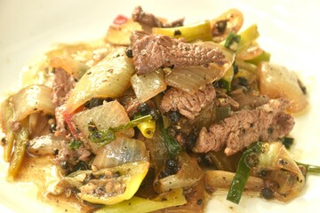 spicy stir fried ostrich meat with onion and black pepper on plate 