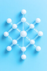 Molecular structure model on blue background with white atoms and connective bonds