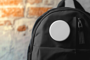 Big white blank pin badge mockup on a black backpack, closeup