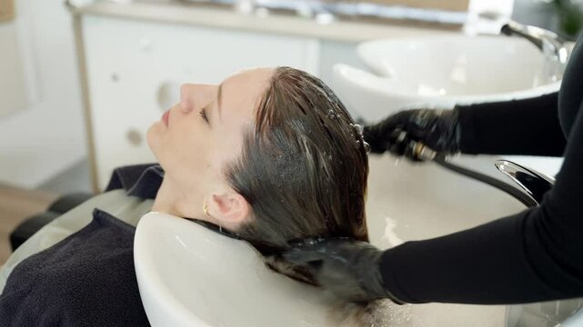 hairdresser giving a head massage to woman client