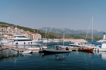 Obraz premium Inflatable motor boats stand next to yachts at the marina berths