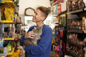 Man with his cute cat in pet shop