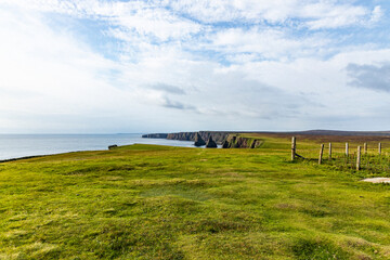 Duncansby Stacks, a breathtaking coastal wonder in Scotland, rise from the North Sea. Standing atop...