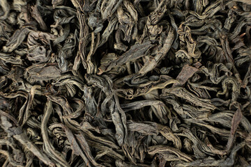 Black large leaf tea leaves macro texture.