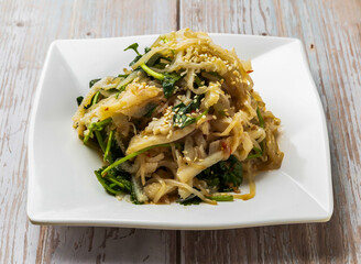 Spicy Beef Stomach Salad with sliced beef tripe topped with sesame seeds and fresh cilantro served in plate on Wood Table Close up Side view of Hong Kong food