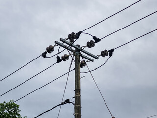 Network of electric cables on electric poles, with a cloudy sky in the afternoon