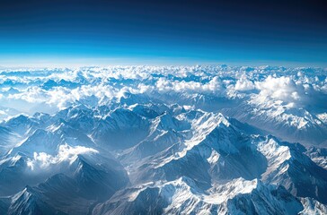 Fototapeta premium Snow-capped mountains contrast beautifully with the deep blue sky and white clouds