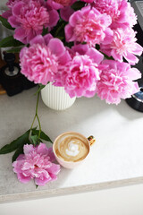 Cup with cappuccino, flowers peony, morning concept, woman's day