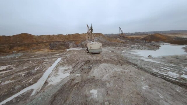 Exploring a dragline excavator at a titanium dioxide mining and processing plant filmed from an FPV drone