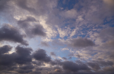 Soft clouds illuminated by the pink light of the sun create a gentle warm hue against the blue sky. Symbolizes harmony and tranquility.