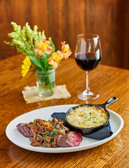 pan seared hanger steak topped with caramelized onions and mushrooms served with potato au gratin