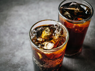 Cola soft drink with ice cubes, Close up of soda fizzy drink in Cold glass on gray background