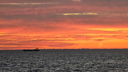wonderful sunset from the ship with sea, houses and harbor as silhouette