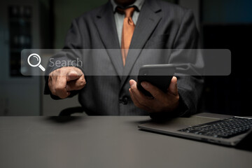 Male businessman clicking internet search page on computer and smart phone touch screen.