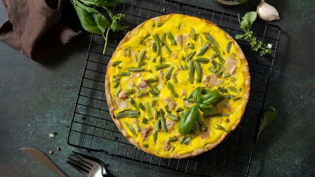 Freshly baked vegetable frittata cooling on rack with herbs and garlic in kitchen setting